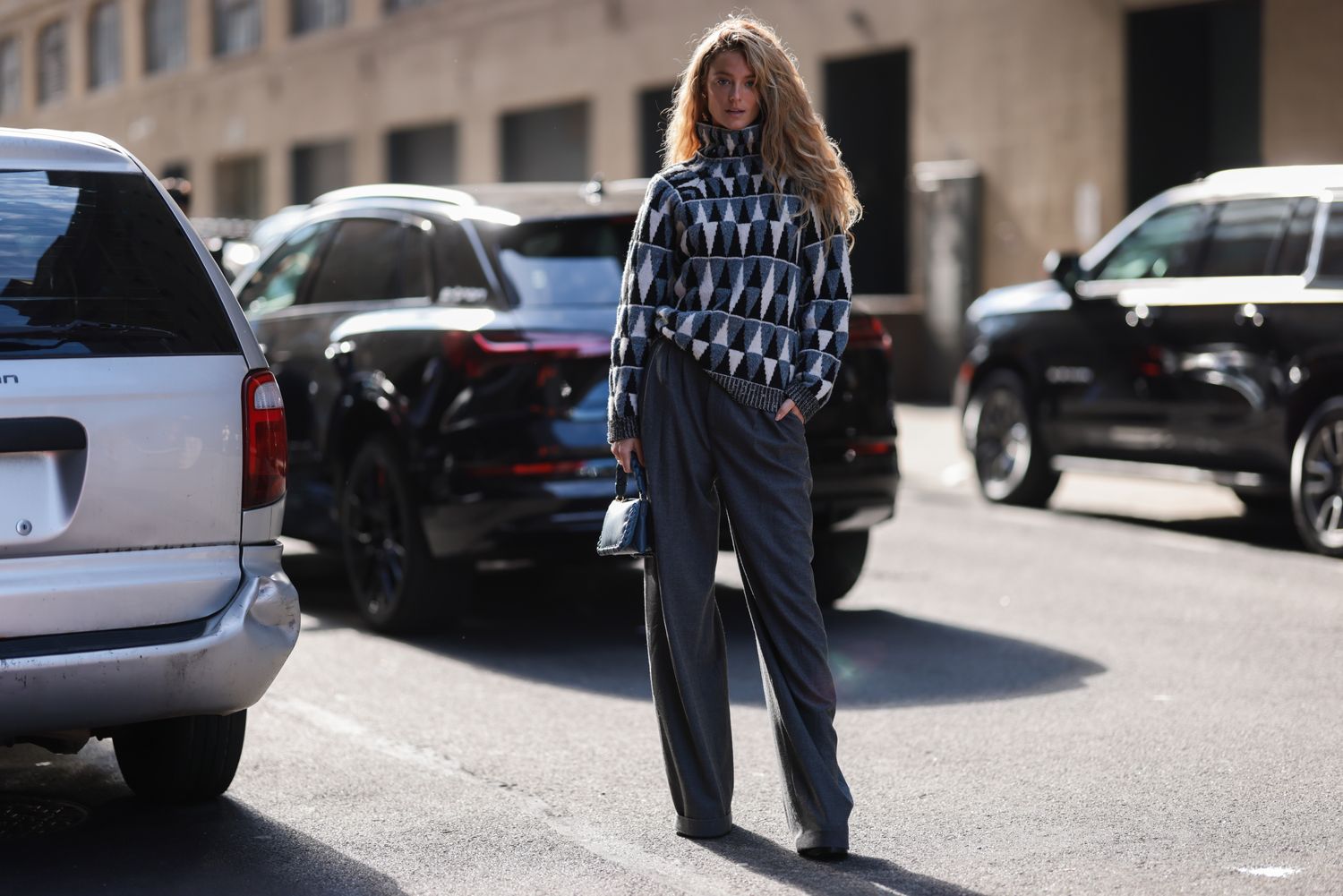 Kate Bock seen wearing blue white pullover, grey wide pants, Altuzarra blue bag and black boots, outside Altuzarra during New York Fashion Week on September 10, 2022 in New York City.